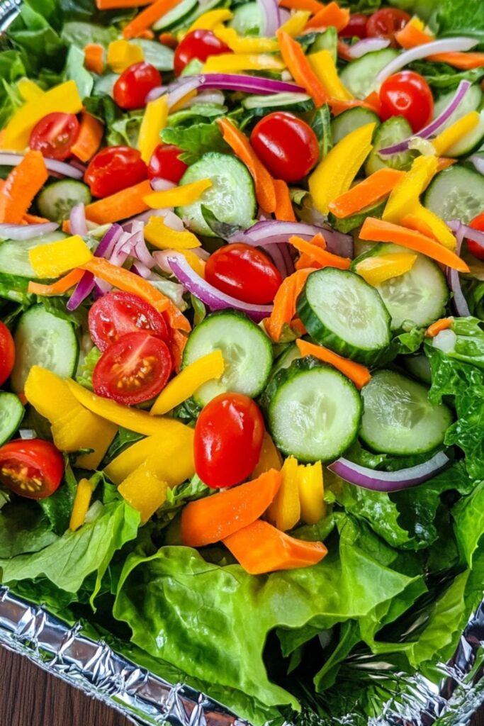 Colorful fresh garden salad served in a convenient aluminum foil tray.