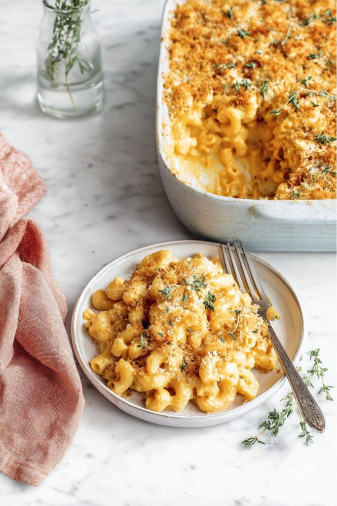 A serving of creamy vegan macaroni and cheese with a golden breadcrumb topping and fresh herbs, perfect for those seeking easy vegan comfort food.