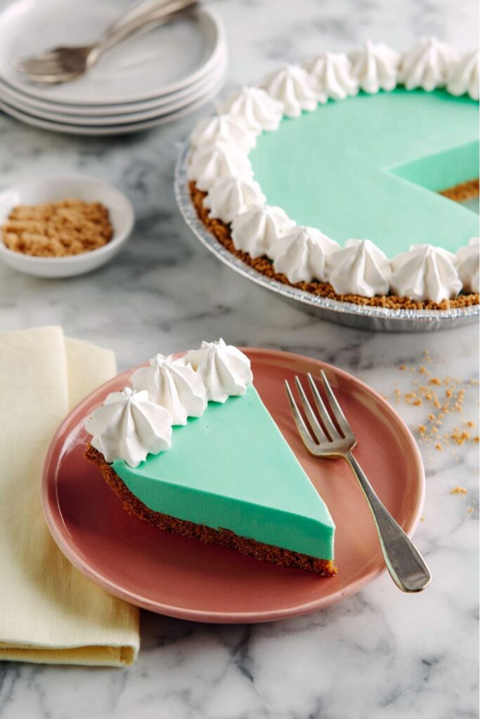 A vibrant teal Baja Blast pie with whipped cream, perfect for a potluck Mexican feast.