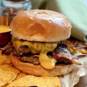 Juicy bacon and cheddar smash burger on a toasted bun with crispy tortilla chips.