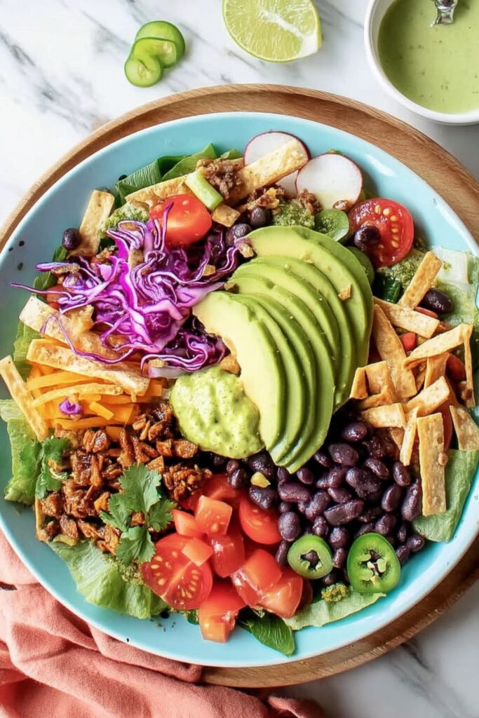 Colorful taco salad with avocado, black beans, cabbage, and tortilla strips, Fresh Cinco de Mayo dishes.