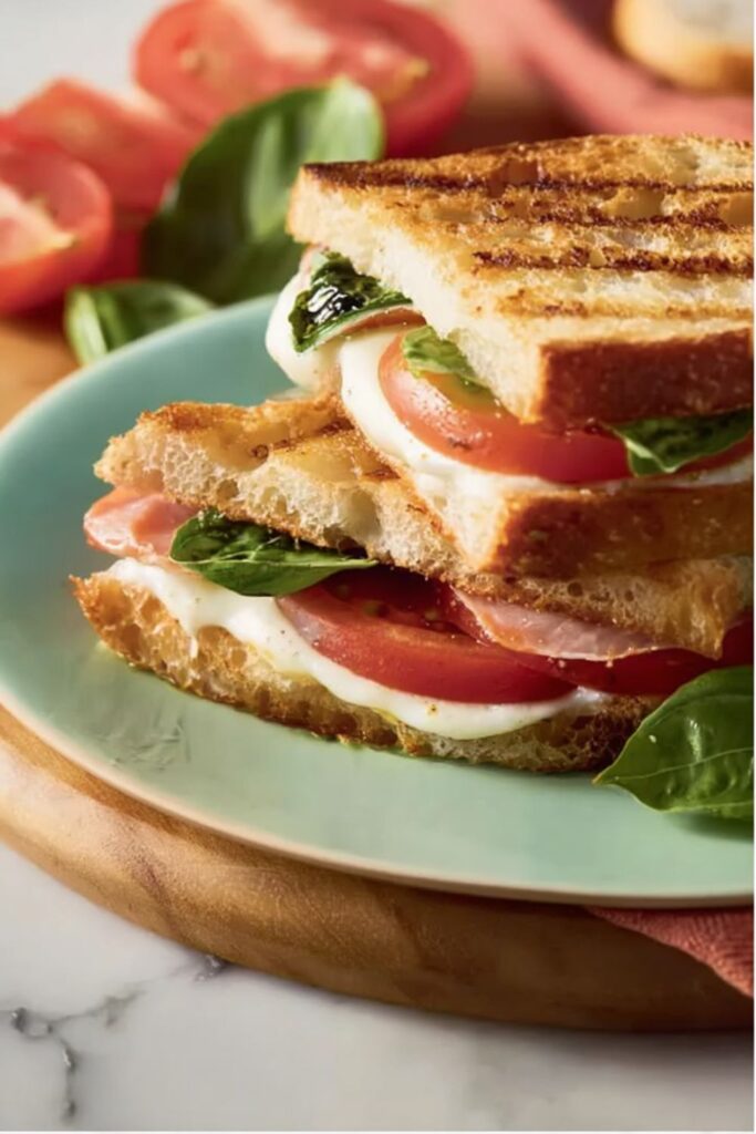 Grilled mozzarella, tomato, basil, and ham sandwich on toasted bread, Stanley Tucci Italian Recipes.