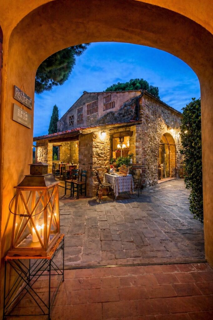 Dreamy Airbnbs in Tuscany at Salvadonica with rustic stone farmhouse courtyard and warm evening lighting