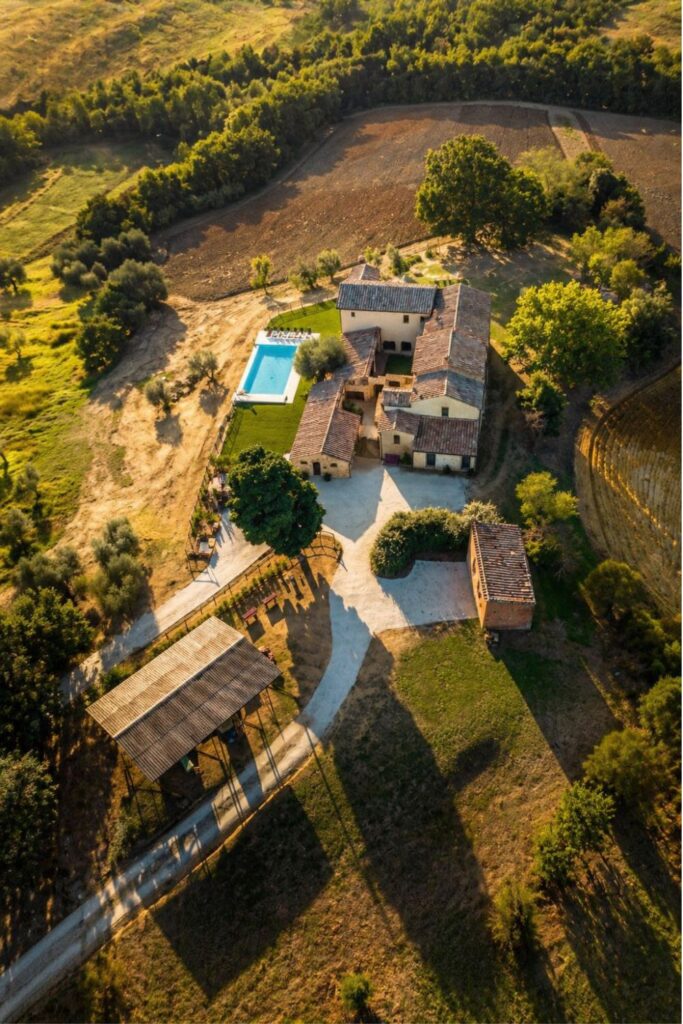 Dreamy Airbnbs in Tuscany at Palazzo Massaini with farmhouse, pool, fields, and olive trees