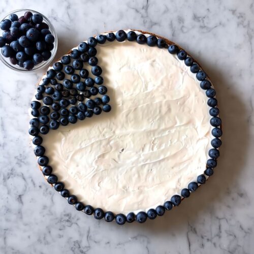 Fresh blueberries forming a border and corner square on an American Flag Fruit Pizza.