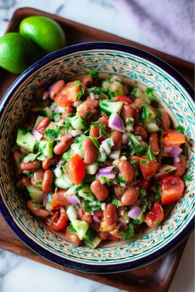 A bowl of vibrant kidney bean salad with cucumber and cilantro, a fresh picnic food choice.
