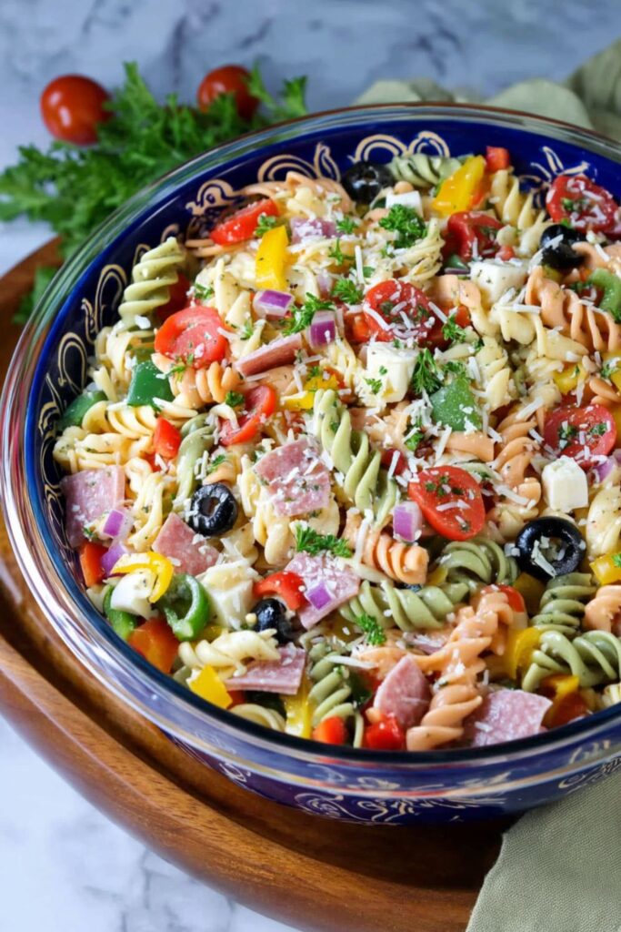 A bowl of tricolor rotini pasta salad with salami, a great choice for party side dishes.