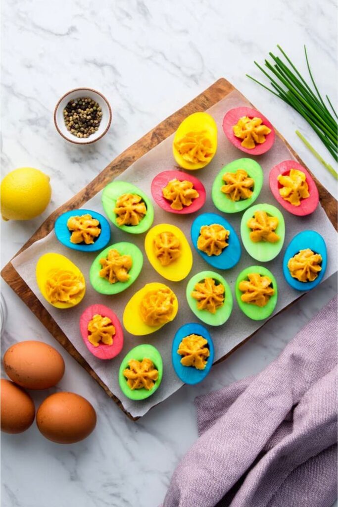 Brightly dyed deviled eggs on a platter, a colorful example of fourth of july party appetizers.