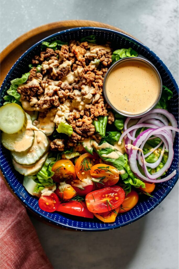 A fresh burger salad bowl with ground beef and special sauce, perfect July 4th food healthy.
