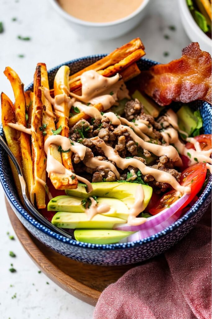 Loaded burger bowl with crispy fries and avocado for a whole30 picnic menu.