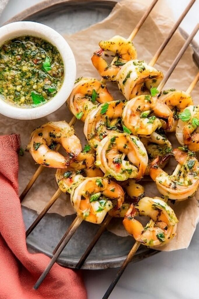 Grilled chimichurri shrimp skewers served with green sauce for a standout whole30 picnic recipes choice.