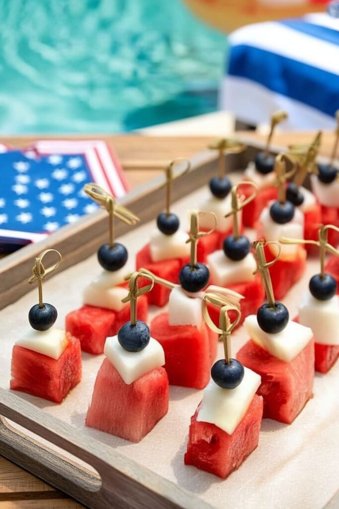 Skewered watermelon, pear, and blueberry cubes as a creative 4th Of July Themed Food option.
