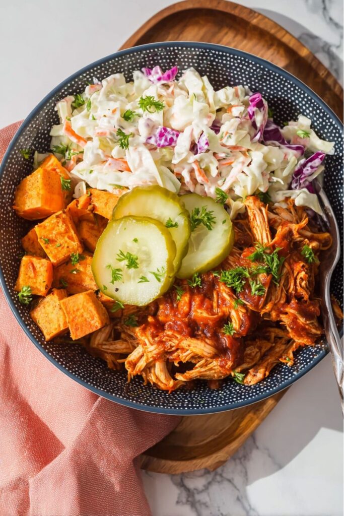 Shredded BBQ chicken bowl with sweet potatoes and coleslaw, a great example of whole30 picnic food.