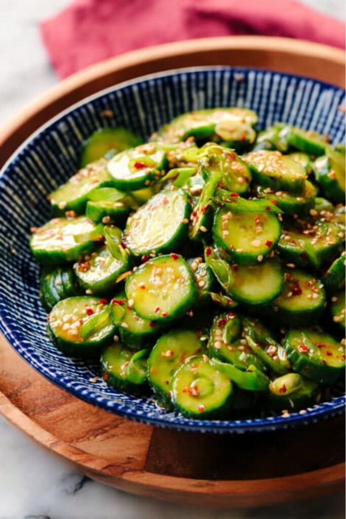 Sliced spicy cucumbers with sesame seeds in a bowl for July 4th food healthy.