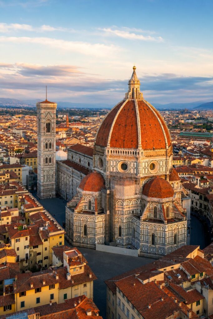 Aerial view of Florence Duomo, Giotto’s Bell Tower, red rooftops, and Tuscan hills at golden hour