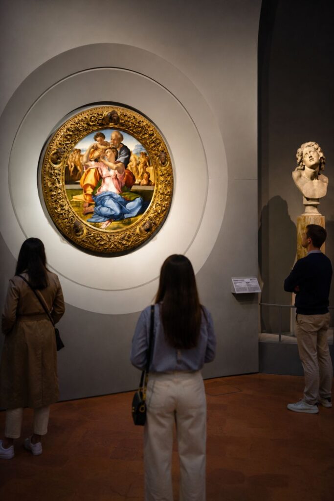 Visitors admire Renaissance paintings inside the softly lit Uffizi Gallery in Florence.